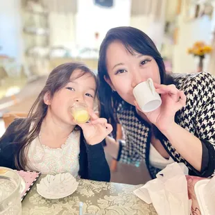 a woman and a young girl sitting at a table