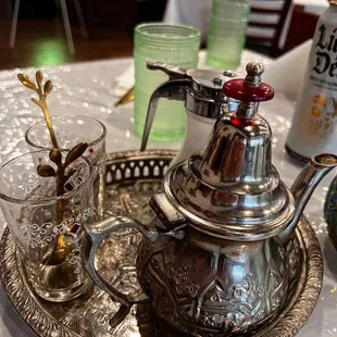 a silver teapot on a silver tray