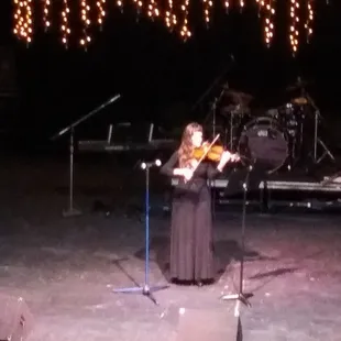 a woman playing a violin on stage