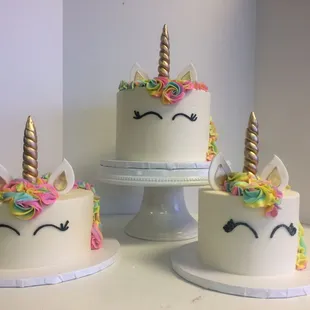 three cakes decorated with unicorn faces