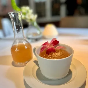  bowl of soup and a pitcher of honey
