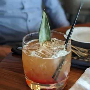 a man sitting at a table with a drink