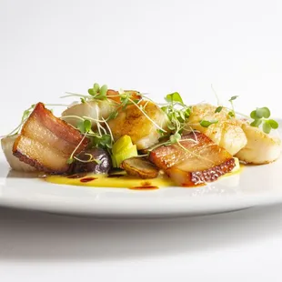 a plate of food with bacon and vegetables