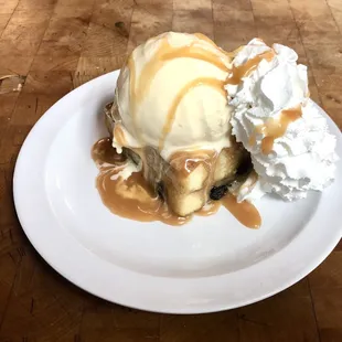 Bread pudding with ice cream and whipped cream and rum caramel sauce, so delicious