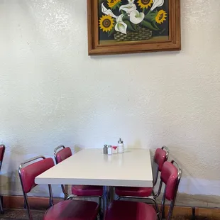 a white table and red chairs