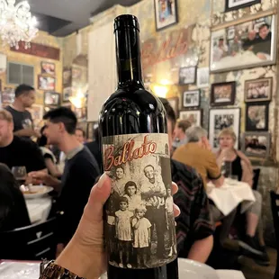 a hand holding a bottle of wine