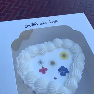 Vanilla cake, vanilla frosting, extra decration and pressed flowers.