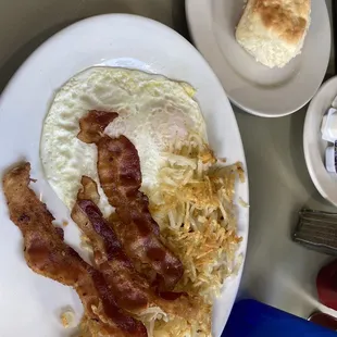 Eggs over easy, bacon, hash browns and a homemade biscuit