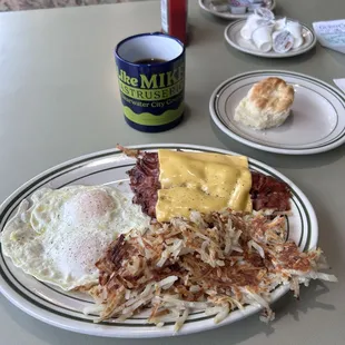 a breakfast of eggs, hash browns, hash browns and a biscuit
