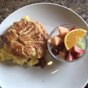 Bacon egg and cheese on a croissant with fresh fruit! What a lovely plate!