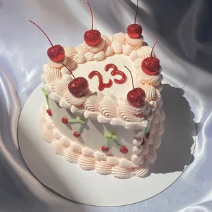 a birthday cake with cherries on top