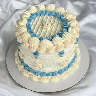 a three tiered cake with blue and white icing