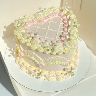 a three tiered cake with pink and white frosting