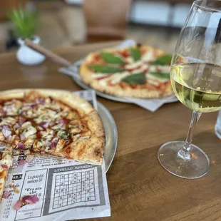 two pizzas and a glass of wine