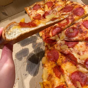 a hand holding a slice of pizza