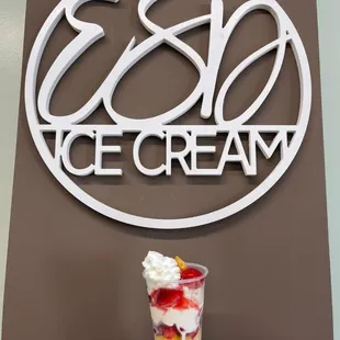 a hand holding a cup of ice cream