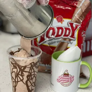 a cup of chocolate ice cream being poured into a cup