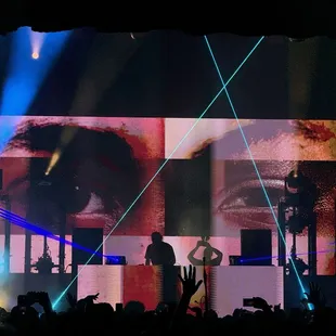 a man on stage with his hands in the air