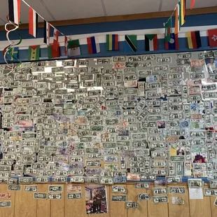 Wall full of money from different countries for people that visited here for good empanadas