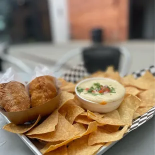 a tray of chips and a bowl of dip
