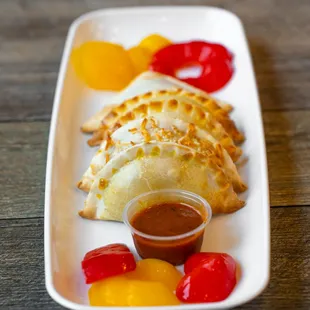 a plate of empanadas and condiments