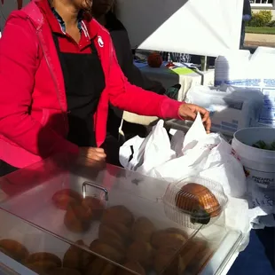 a woman selling donuts