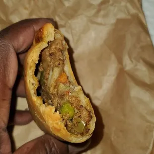 a hand holding a sandwich