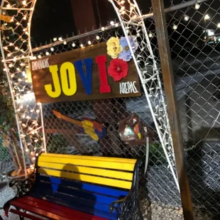a colorful bench in front of a fence