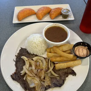 Empanadas, steak and Smothered onions with beans, rice and yuca fries.