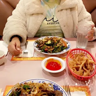 a woman sitting at a table with plates of food