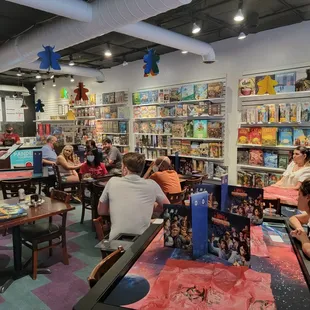 people sitting at tables in a game store