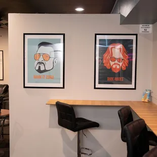a bar with two chairs and two framed pictures