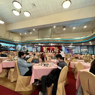 diners sitting at tables with pink tablecloths