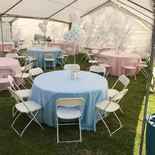 60 inch round tables, white chairs, Pink and blue linen, swirl organza overlay, under a canopy tent