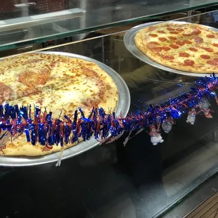 pepperoni and cheese pizzas in a display case
