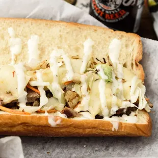 BBQ Brisket Sandwich: BBQ Beef Brisket grilled with sautéed onions, shredded Cole Slaw, BBQ Sauce, topped with pepper jack and ranch