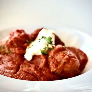 Meatballs in tomato sauce topped with Ricotta cheese