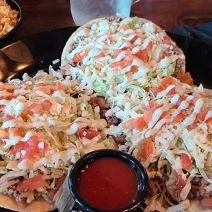 a plate of tacos with a side of salsa