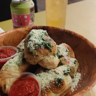 a wooden bowl filled with pizza and sauce