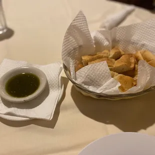 a bowl of pita bread and a bowl of dipping sauce