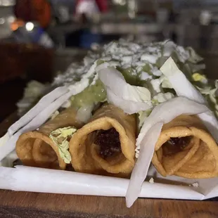 a plate of tacos with lettuce and onions