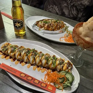 two plates of sushi and a glass of beer