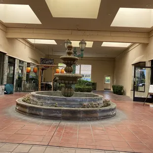 Resturant tucked back away from parking lot. Behind a fountain.