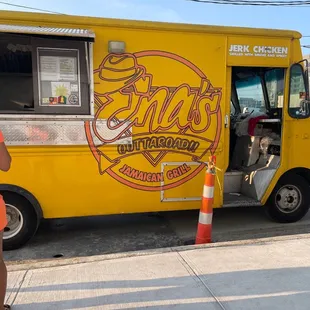 a woman standing in front of a food truck