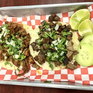 Pastor and asada tacos. Comes with lime and cucumbers on the side