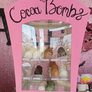 a pink display case with a sign that says coca bombs