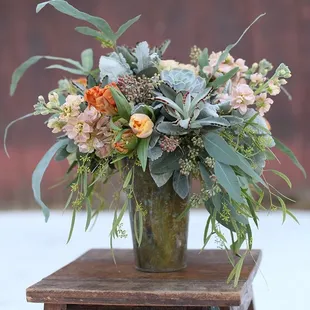 Ornamental cabbage with stock flower and peach roses set this for a low and lush design.