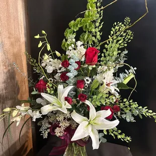 white lilies set among red roses and white orchids.