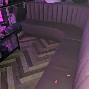 a purple couch with a tv in the corner