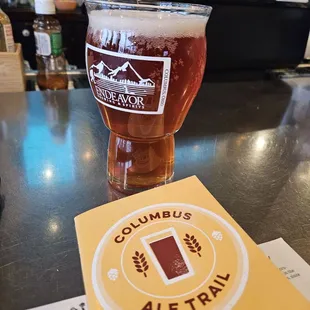 a glass of beer and a menu